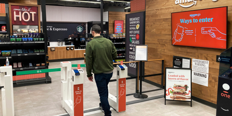A man uses his smartphone to enter an Amazon Go convenience store in New York