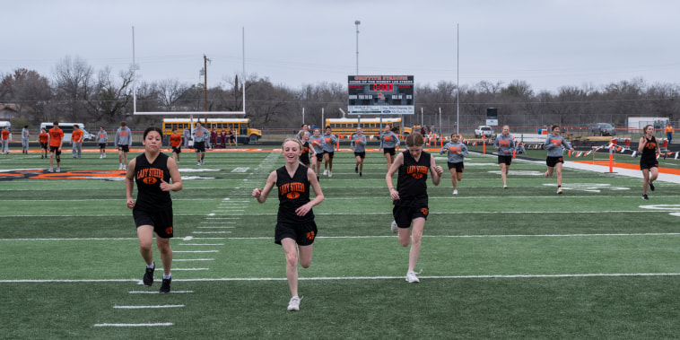 Members of Robert Lee ISD’s middle and high schools warm up before a track meet in Robert Lee, Texas on March 9, 2023.