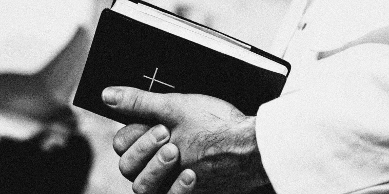 Man in popes garment holding holy bible