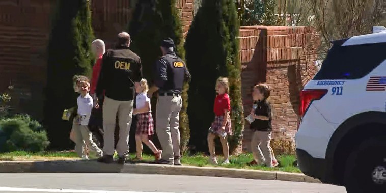 Law enforcement officers lead children away from the scene of a shooting at The Covenant School, a private Christian school in Nashville, Tenn., on March 27, 2023.
