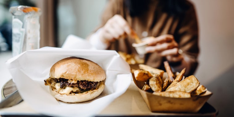 Una pareja come una hamburguesa en un restaurante.