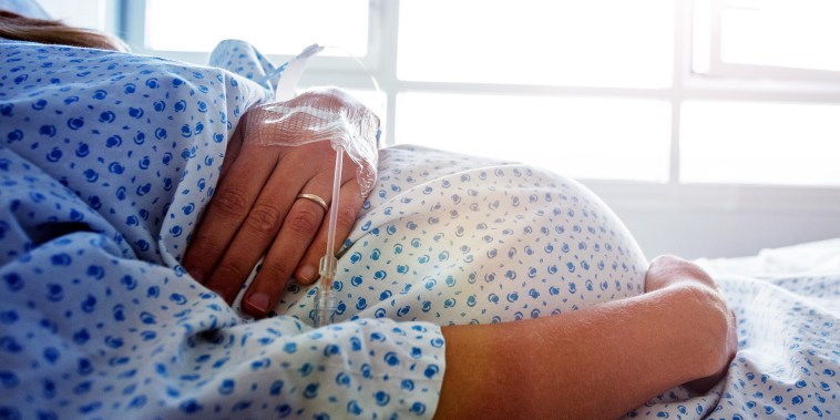 Close-up of a pregnant woman's belly in hospital.