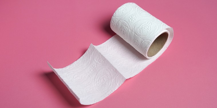 White toilet paper roll with  on pink background