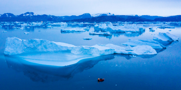 A boat navigates through icebergs near the town of Kulusuk, Greenland
