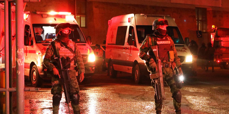 Firefighters and Mexican soldiers stand during a rescue for migrants from an immigration station in Ciudad Juarez, Mexico