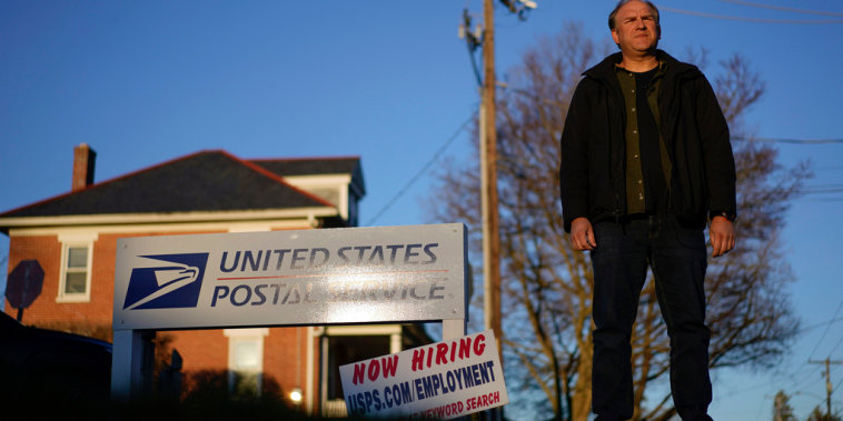 Gerald Groff posa frente a un anuncio de oferta de empleos del Servicio Postal de Estados Unidos, el 8 de marzo de 2023 en Quarryville, Pennsylvania.