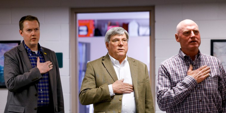 Woodland Park School Board Vice President David Illingworth II, left, Interim Superintendent Kenneth Witt, center, and President David Rusterholtz, right, say the Pledge of Allegiance before the start of the Board of Education meeting on April 12, 2023 in Woodland Park, Colo.