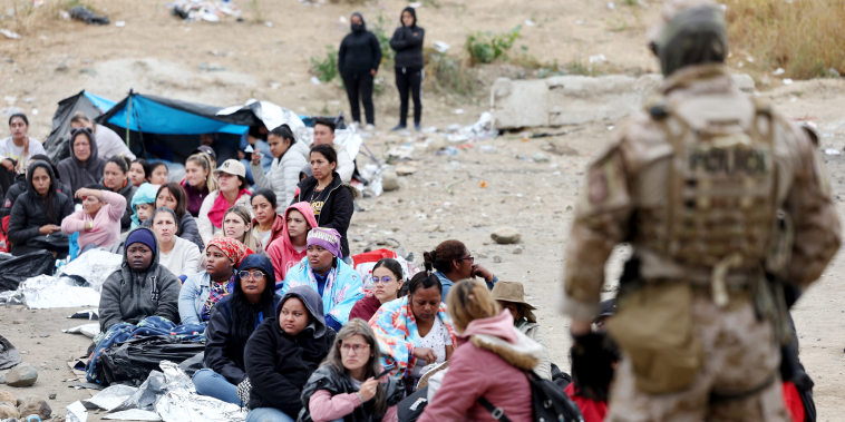 Asylum-seekers wait in a makeshift camp between border walls on May 13, 2023 in San Diego.
