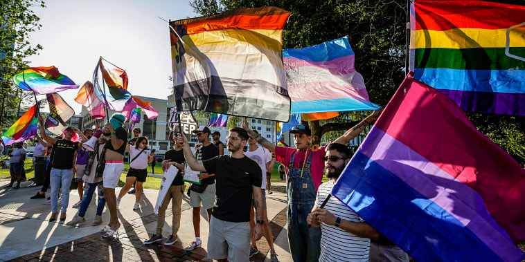 Image: Protesters wave pride flags as the join others, including immigrants rights and abortion rights groups and members of the LGBTQ community from across the state in a rally and march on May 1, 2023, in Orlando, Fla.