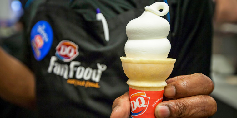 A Dairy Queen employee displays an ice cream cone.