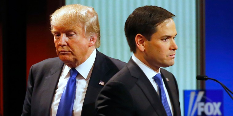 Then-presidential candidate Donald Trump passes behind Sen. Marco Rubio during a commercial break at a primary debate