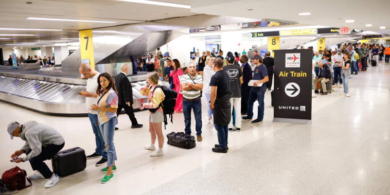 People wait to reschedule their flights at Newark International Airport, in Newark, N.J.