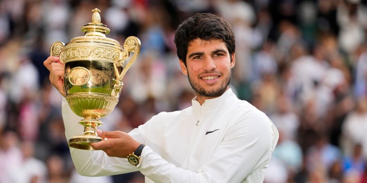 Carlos Alcaraz celebrates with the trophy after beating Novak Djokovic at the Wimbledon tennis championships in London
