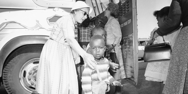 Two unidentified women, residents of Hyannis, Mass., help some of the nine children of Lela Mae Williams off the bus, June 8, 1962.