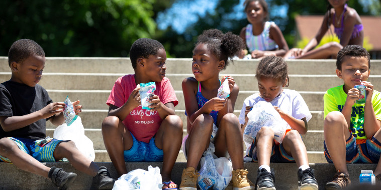 Kids on the steps at Dempsey Aquatic Center where the Cincinnati Public Schools serve both breakfast and lunch during the summer as part of a federally funded Summer Food Service Program in June 2019.