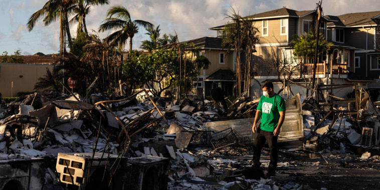 A Mercy Worldwide volunteer assesses the damage at a charred apartment complex in the aftermath of a wildfire in Lahaina, western Maui, Hawaii, on Aug. 12, 2023.