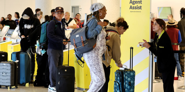 People check-in at Spirit Airlines at Los Angeles International Airport