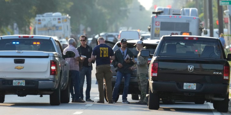Law enforcement officials investigate the scene of a mass shooting at a Dollar General store, Saturday, Aug. 26, 2023, in Jacksonville, Fla. 