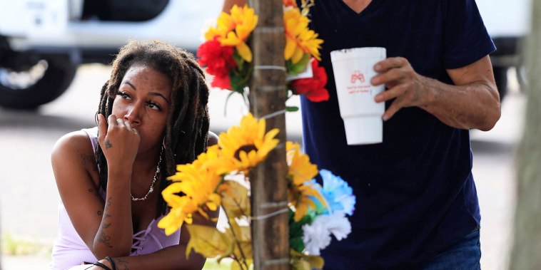 A woman pays her respects to shooting victims on Aug. 28, 2023 near the site of the Dollar General store shooting In Jacksonville, Fla.
