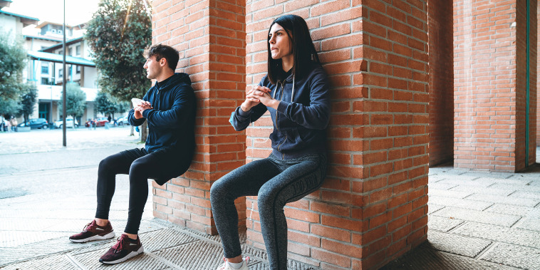 Two people doing wall sits together.