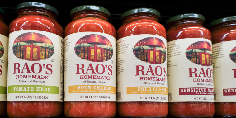 Jars of Rao's sauces are displayed along a grocery store's shelves. 