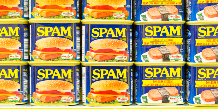 Spam canned meat stacked vertically in store shelf. 