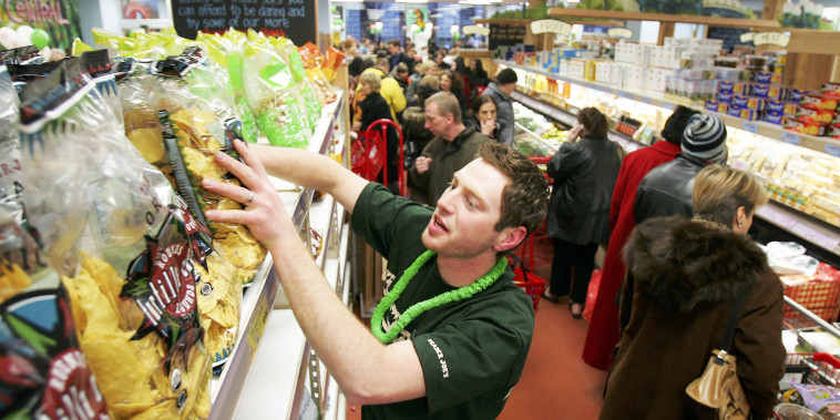 Jason Baglin restocks chips as shoppers line up inside Trader Joe's in NYC. 
