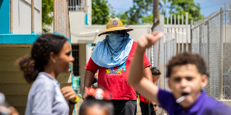 Image: A school maintenance worker wears sun protection at the Escuela Elemental Santiago Iglesias Pantín school in San Juan, Puerto Rico on Sept. 7, 2023. 
