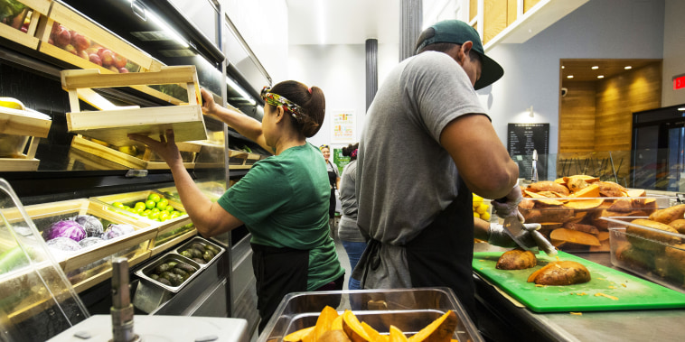 Workers prepare food inside a Sweetgreen