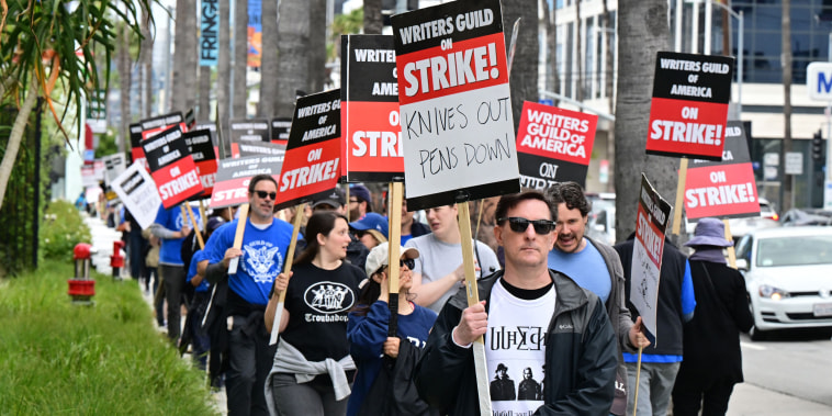 Members of the Writers Guild of America walk the picket line in front of Netflix in Hollywood, Calif.,