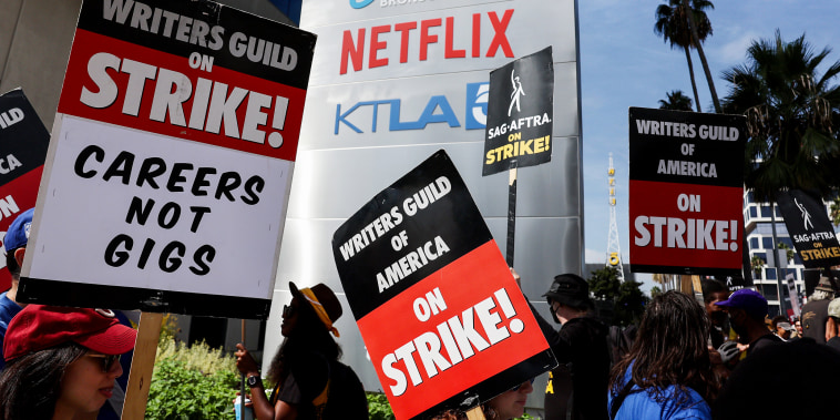 Striking WGA members picket with striking SAG-AFTRA members outside Netflix studios in Los Angeles on Sept. 22, 2023.