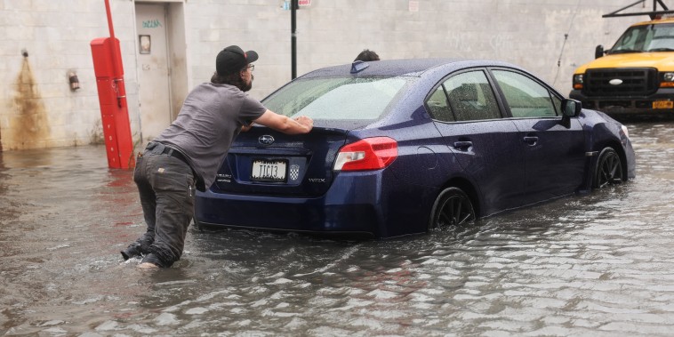 A car is pushed through flooded streets in Brooklyn's Red Hook neighborhood on Sept. 29, 2023, in New York.