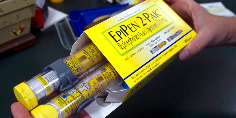 Una persona sostiene un paquete de Epipen en una farmacia.
