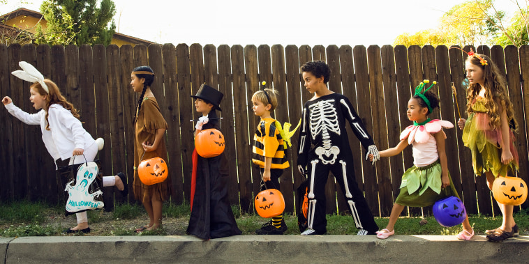 Children in Halloween costumes holding hands
