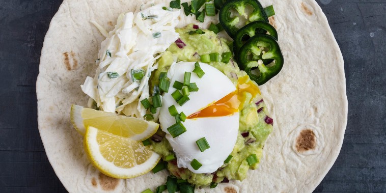Mexican style breakfast with poached egg, guacamole on flour tortilla