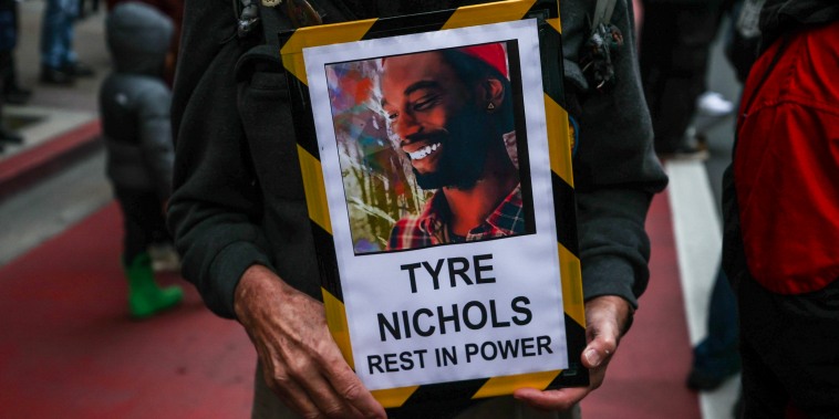 A protestor holds a sign with a photo of Tyre Nichols