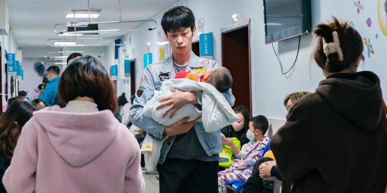 A man holds a child suffering from a respiratory illness.