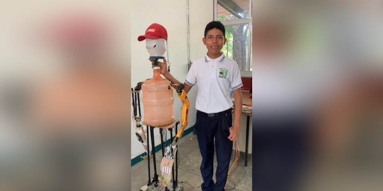 Daniel Grapain Moreno posa junto a Larry, el robot que presentó en su escuela.