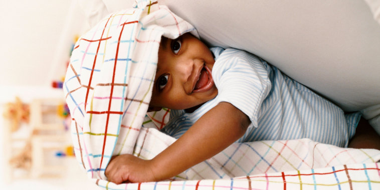 Young Boy Sitting on a Chair and Playing Under a Sheet