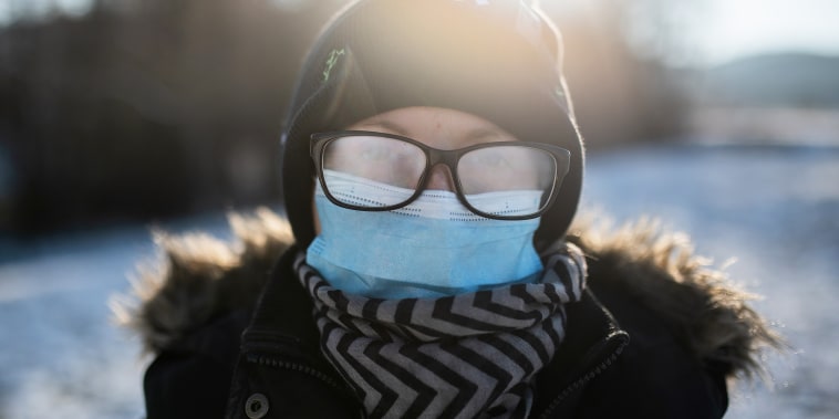 Woman Winter walk with face mask and fogged up eyeglasses.