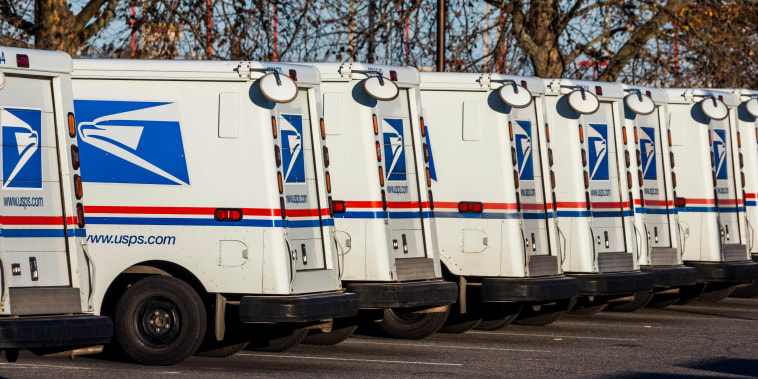 arow of parked United States Postal Service vans