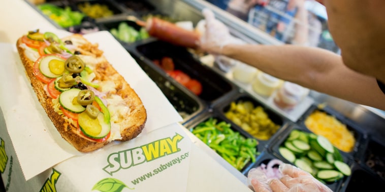 A worker makes a sandwich inside the fast food chain Subway in Hannover, Germany, 21 August 2015. 