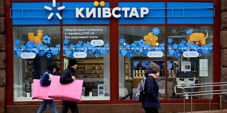 People walk past a Kyivstar store in Kyiv