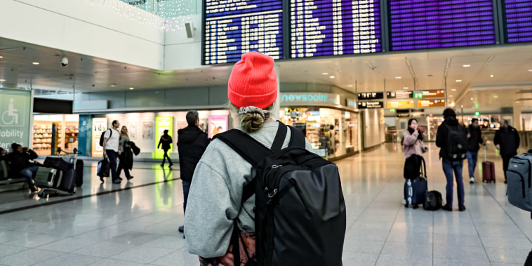 A person looks at a flight call board at the Munich International Airport