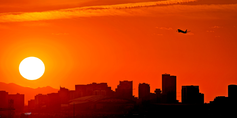 A Jet takes flight from Sky Harbor International Airport as the sun sets over downtown Phoenix, Wednesday, July 12, 2023. Millions of people around the Southwest are living through a historic heat wave. Phoenix is currently America's hottest large city with temperatures forecast to hit as high as 119 degrees Fahrenheit.
