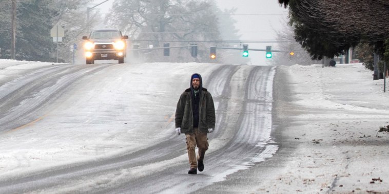 A man walks on the road in the snow on Wednesday, Jan. 17, 2024, in Tigard, Ore. 