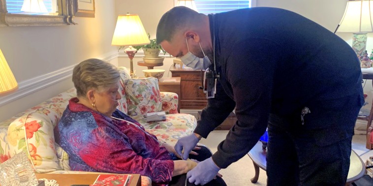 Manny Mill, right, a community paramedic, helping Florence Sparks, 80, of Pineville, NC, with an IV. 