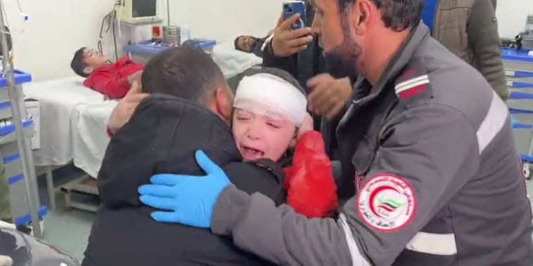 Palestinian doctor Dr. Rami Abu Libdeh holds his 9-year-old son, Mohammad, at a hospital in Rafah, Gaza, on Feb. 8, 2024.
