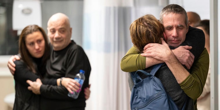 Hostages Fernando Simon Marman, right, and Luis Har, second from left, hug relatives after being rescued from captivity in the Gaza Strip, at the Sheba Medical Center in Ramat Gan, Israel, Monday, Feb. 12, 2024. 