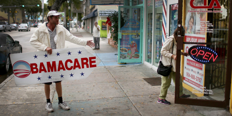 Man holding "Obamacare" sign.